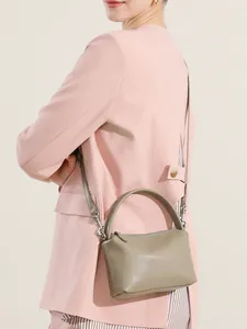 Borsa Boston classica in pelle verde con manici e tracolla regolabile indossata dal modello