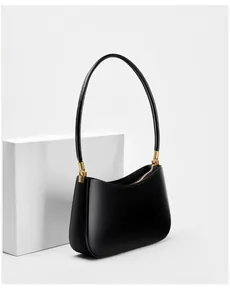 Detailed shot of sleek black leather shoulder bag with gold zipper and hardware