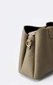 Dettaglio laterale della borsa in pelle martellata con cuciture e anello a D oro