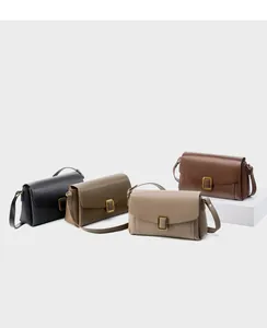 Close-up of elegant leather shoulder bags in various colors with gold metal buckles