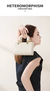 Détail d'un sac à main en cuir crème avec motif crocodile et accents métalliques dorés