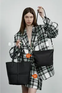 Detail of black leather bucket bag set with inner zipper pouch and lychee texture finish