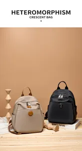 Detail view of large Oxford cloth backpacks in beige and black with leather trim and logo