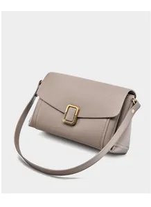 Detail view of greige leather shoulder bag with gold square metal buckle and fine texture