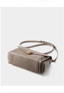 Detail of taupe vegetable tanned leather bag with vintage gold square metal buckle