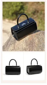 Detailed views of a black leather box handbag with silver hardware and a structured handle