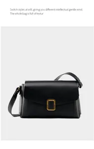 Detailed view of black leather shoulder bag featuring a gold square metallic buckle