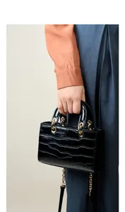 Détail du sac à main noir en cuir gaufré crocodile avec anneaux dorés et chaîne