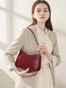 Chic burgundy leather underarm bag with gold accents for versatile daily styling