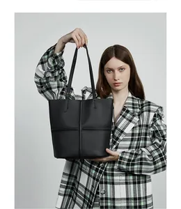 Close-up of black lychee-grain leather tote bag with cross-stitch sewing details