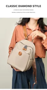 Detailed view of beige Oxford fabric backpack with leather logo patch and zipper pocket