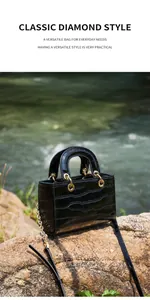 Gros plan détaillé du cuir noir embossé crocodile et de la chaîne dorée du sac à main