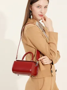 Minimalist dark red leather box handbag for women shown with top handle and shoulder strap