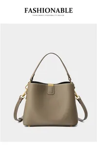 Dettaglio della pelle martellata e finiture in metallo dorato sulla borsa color taupe