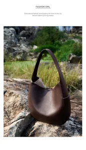 Detail of premium lychee grain leather texture on a large dark brown hobo tote bag