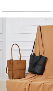 Detail of minimalist leather tote bags with cross-stitch design and adjustable shoulder strap