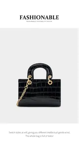 Détail du sac à main noir à relief crocodile avec élégantes garnitures dorées et anse
