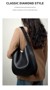 Detail view of premium black pebbled leather hobo tote bag on model shoulder