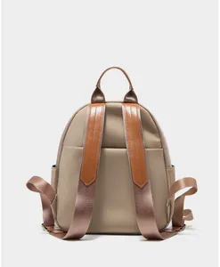 Detailed back view of khaki nylon backpack with brown leather trim and side pockets