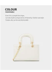 Détail du sac à main blanc motif crocodile avec chaîne dorée et poignée ronde