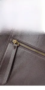 Detail of dark brown leather tote bag featuring a hidden back pocket with zinc alloy zipper