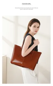Brown leather tote bag featuring dual long handles and premium oiled texture detail