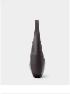 Detail view of smooth lychee grain texture and stitching on dark brown leather hobo bag
