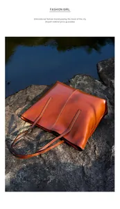 Detailed close-up of a premium brown leather tote bag resting on natural river rocks