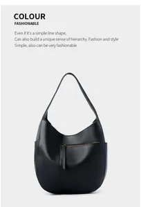 Detail of black pebbled leather tote bag featuring a front zipper pocket and side slots