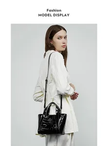 Borsa a mano moderna in pelle goffrata coccodrillo nera mostrata da modella per stile