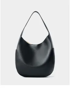 Detailed macro view of black lychee grain leather texture on hobo shoulder bag