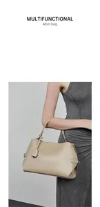 Gros plan sur la texture du sac en cuir beige avec bandoulière fine et pendentif décoratif