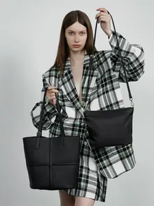 Genuine leather black tote bag and shoulder bag with gold hardware on fashion model