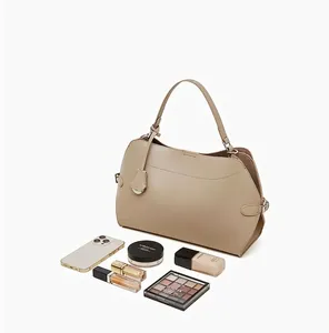Sac fourre-tout spacieux en cuir beige montrant sa grande capacité avec cosmétiques