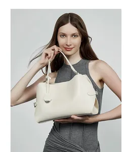 Détail d'un élégant sac à main en cuir beige avec garnitures argentées et fini lisse