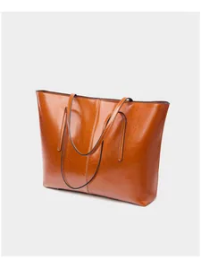Detailed close-up of warm brown tote bag with high-gloss leather finish and stitching