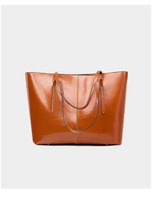 Detailed view of large brown oil wax leather tote bag with glossy finish and dual straps