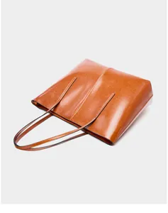 Detail of a brown oil wax leather tote bag with vertical stitching and slim straps