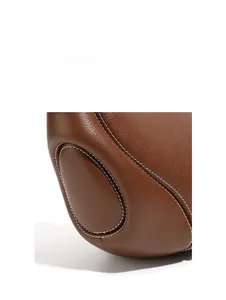 Dettaglio della borsa in pelle caramello con doppie cuciture bianche e grana naturale
