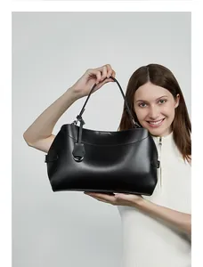 Détail d'un sac à main en cuir noir avec boucle métallique et texture de cuir raffinée