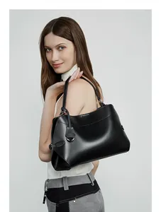 Vue latérale détaillée d'un sac cabas en cuir noir porté par un mannequin en studio épuré