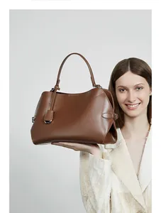 Détail du bord ondulé et des coutures précises sur un grand sac à main en cuir brun