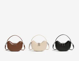 Three half-moon leather handbags in brown, cream white, and black colors display