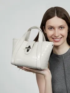 Elegante borsa tote bianca in pelle a coccodrillo con chiusura girevole argentata e manici