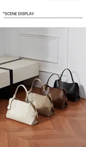 Vue détaillée de quatre sacs à main en cuir en beige, kaki, marron et noir sur parquet