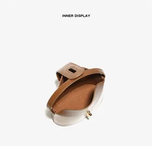 Detail view of genuine leather handbag with gold twist lock and spacious inner pocket