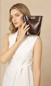 Détail du sac seau en cuir de vachette ciré marron foncé avec chaîne argentée