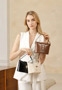 Detail view of genuine leather handbags in three colors with luxury gold capsule locks