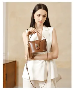 Close-up of brown glossy leather bucket bag featuring a vintage gold metal lock