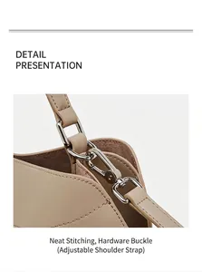 Gros plan du sac en cuir beige avec coutures précises et boucle métallique argentée